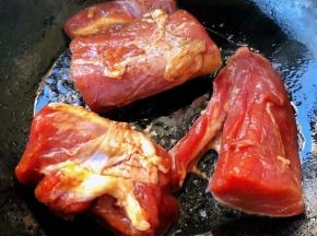 锅中倒入底油加热放入入味的里脊肉中火煎制