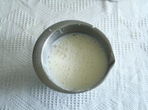 牛奶煮至基本沸腾，一边倒入蛋黄糊中，一边用电动打蛋器高度打匀。