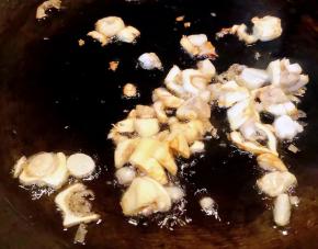 锅中倒入底油加热放入蒜粒爆香