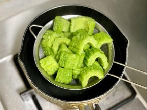 锅里烧开水，把苦瓜焯烫1分钟，这样能去除掉一些苦味和大部分的草酸。然后捞出沥干水分。