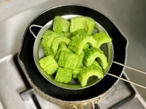 锅里烧开水，把苦瓜焯烫1分钟，这样能去除掉一些苦味和大部分的草酸。然后捞出沥干水分。