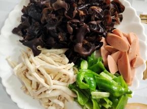 木耳提前泡发好，洗净，沥干水分。海鲜菇去蒂洗净。青椒去蒂去籽洗净切成小块，火腿肠切成片备用！