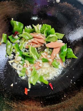 放入火腿肠和青椒翻炒均匀！