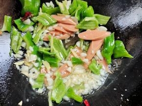 放入火腿肠和青椒翻炒均匀！