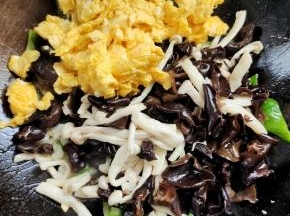 放入海鲜菇木耳和炒好的鸡蛋，翻炒均匀！