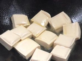 加入豆腐，中火煎香，煎至两面金黄