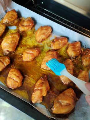 中途观察一下，看鸡翅表面干巴了，把烤盘里面烤出来的油，均匀的刷在鸡翅中上。再继续烤！