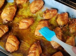 中途观察一下，看鸡翅表面干巴了，把烤盘里面烤出来的油，均匀的刷在鸡翅中上。再继续烤！