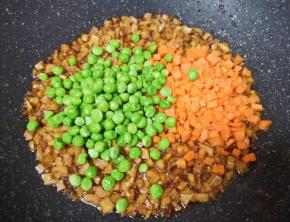 下入豌豆和胡萝卜翻炒均匀。