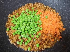 下入豌豆和胡萝卜翻炒均匀。