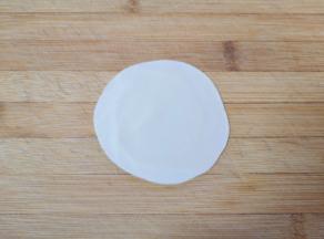 准备好饺子皮，把饺子皮把边缘擀薄让饺子皮变大，加工成烧麦皮。 