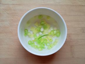 小葱葱白和生姜片切碎放入小碗，加入半碗热水泡成葱姜水备用。