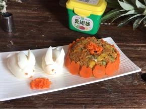 倒扣在盘中，摆上小白兔和萝卜碎，把胡萝卜兔摆在米饭周边