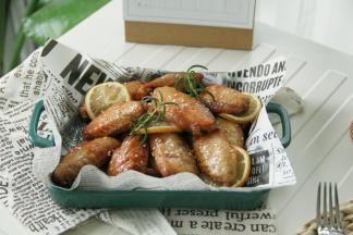 烤完取出，装盘，磨上适量黑胡椒，撒上一把白芝麻，装饰2根迷迭香！
好吃的舔手指的柠香黑胡椒烤翅就完成啦！非常入味，淡淡柠檬香，混合着黑胡椒风味，一点不油腻！