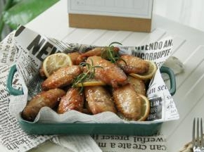 烤完取出，装盘，磨上适量黑胡椒，撒上一把白芝麻，装饰2根迷迭香！
好吃的舔手指的柠香黑胡椒烤翅就完成啦！非常入味，淡淡柠檬香，混合着黑胡椒风味，一点不油腻！