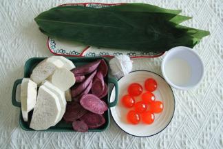 准备材料。新鲜宽粽叶清洗干净（根部可以剪掉一点点尖角），荔浦芋头和紫薯处理成薄片后上蒸锅蒸15-20分钟蒸熟。咸鸭蛋黄是新鲜现敲的。