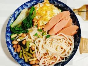 摆上煎好的荷包蛋，火腿肠，酸蒜苔花生，撒上适量的葱花即可开吃！