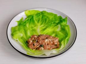 取一片菜叶放上适量的肉馅儿。