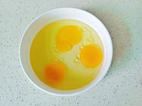 鸡蛋磕入碗里，加上玉米油。