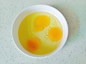 鸡蛋磕入碗里，加上玉米油。