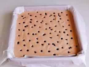 模具垫上油纸，倒入蛋糕糊，轻轻震出气泡，撒上耐高温巧克力。