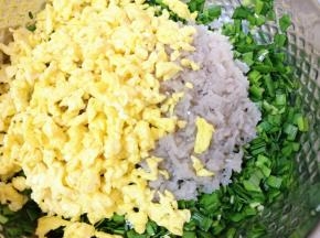 将碎粉条和炒好的鸡蛋一起放进韭菜里面搅拌均匀。