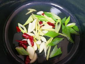 炒锅内倒适量的食用油烧热，下入葱姜蒜和干红辣椒炒香。