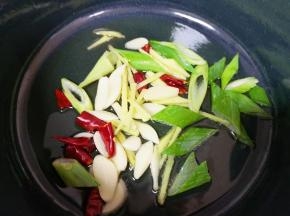 炒锅内倒适量的食用油烧热，下入葱姜蒜和干红辣椒炒香。