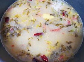 下入鱼头和鱼骨，加入酸菜鱼调料里面的骨汤包烧开，煮两分钟。