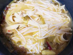 下入准备好的豆皮和金针菇煮开。