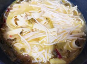 下入准备好的豆皮和金针菇煮开。