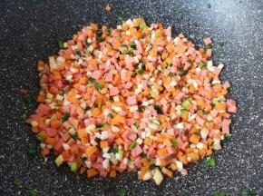 下入香菇、火腿肠和胡萝卜翻炒均匀，放点盐调味。