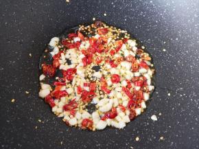 炒锅内倒适量的食用油烧热，下入大蒜和辣椒段炒香。