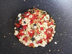 炒锅内倒适量的食用油烧热，下入大蒜和辣椒段炒香。