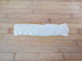 饧好的面片取出放在案板上，将边缘用手指压扁。