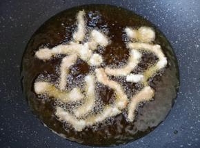 锅里倒多一些食用油烧至6成热，将里脊肉一根一根下入油锅，炸至淡黄色捞出。