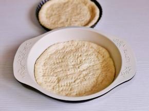 用擀面杖擀成圆饼，放入盘中，用叉子扎出不规则小孔。