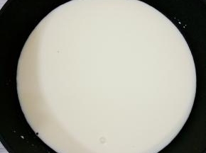 把牛奶倒入锅中，煮到微开端离