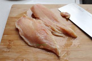 鸡胸肉室温内解冻，清洗干净，去外表的薄膜，肥肉。然后对半切块，让人鸡胸肉变成二块。