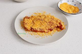 从冰箱取出，均匀裹一层蛋液，再裹一层面包糠。为什么要用蛋液？涂抹一层鸡蛋液，可以把面包糠粘住，炸出的鸡排更酥脆。