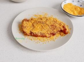 从冰箱取出，均匀裹一层蛋液，再裹一层面包糠。为什么要用蛋液？涂抹一层鸡蛋液，可以把面包糠粘住，炸出的鸡排更酥脆。