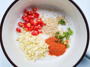 先来调个酸辣汁：将1勺蒜蓉、1勺葱花、1勺辣椒粉、1勺熟芝麻，1勺小米椒圈放入盘中，