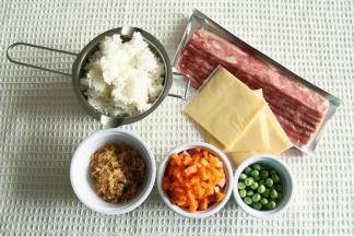 材料准备。米饭建议用冷却的米饭，比较容易炒。香肠、洗干净的胡萝卜切丁。培根提前解冻。