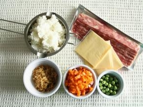 材料准备。米饭建议用冷却的米饭，比较容易炒。香肠、洗干净的胡萝卜切丁。培根提前解冻。