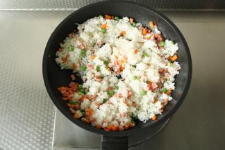 翻炒至材料微微变软，倒入米饭炒散。