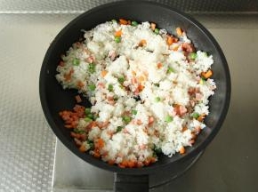 翻炒至材料微微变软，倒入米饭炒散。