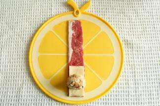 一条培根铺平，底部放上半片芝士，放上一个团成椭圆形的米饭团。