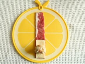 一条培根铺平，底部放上半片芝士，放上一个团成椭圆形的米饭团。