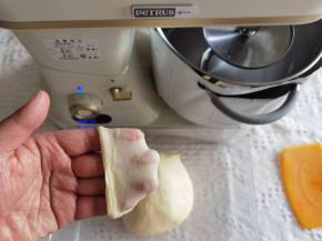 4、转1档打至黄油与面团融合，转4-5档打至面团光滑挂钩。取出面团折叠收圆，检查膜状态。轻扯开薄而结实的膜，无需手套膜状态。