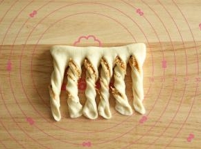 8、上半部分往下对折，顶部不切断，底部均分成6条。每条稍拉长逆时针转3圈，底边压薄。
